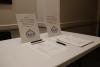 A white table with pens and the TALCB meeting sign-in sheet atop it. 